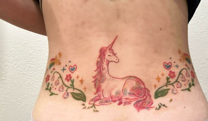 Unicorn with flowers tattoo artist design on lower back, questionable ideas.