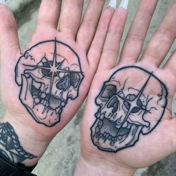 Two skull tattoo artist designs on palms, questionable ideas.