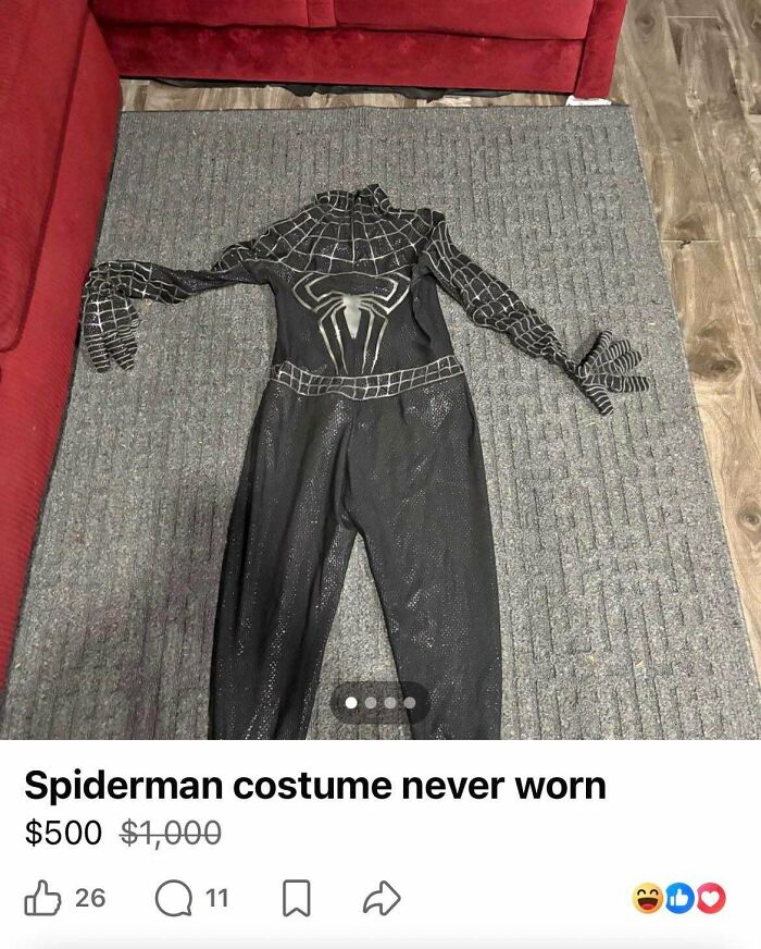 A black Spiderman costume with a silver spider emblem, advertised as never worn in unhinged marketplace listings.