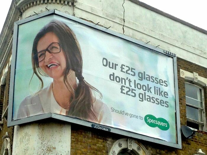 A billboard showing a woman wearing poorly fitting glasses, a ridiculous you had one job fail for an optician advert.