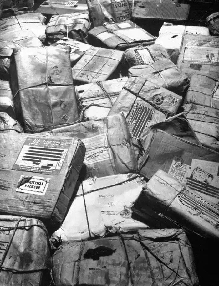 Historical photos: A large pile of tied-up and wrapped packages, some labeled with a Christmas Package sticker.