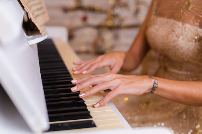 Hands of woman playing piano at wedding reception