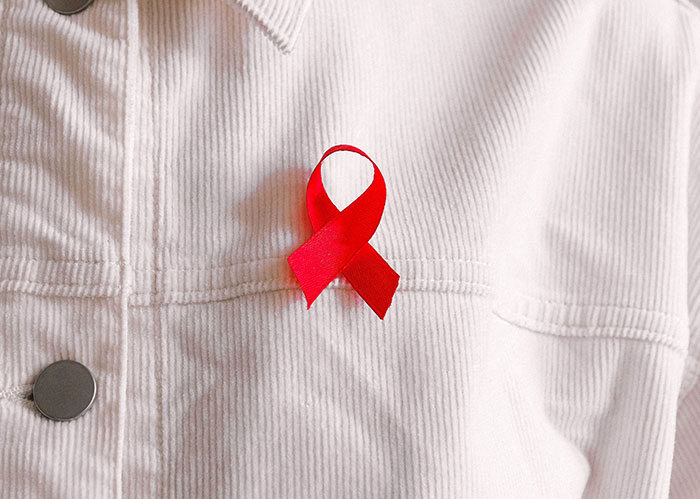 A red ribbon on a white shirt, symbolizing awareness for popular kids who peaked in high school.