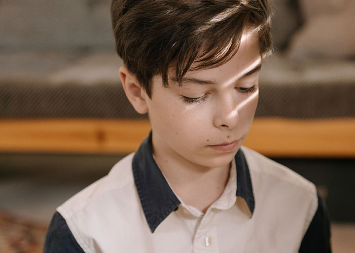 A young boy with a sad expression, broken trust by close friends.