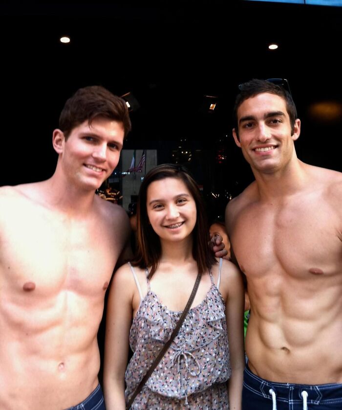 Woman with two shirtless men posing for photo