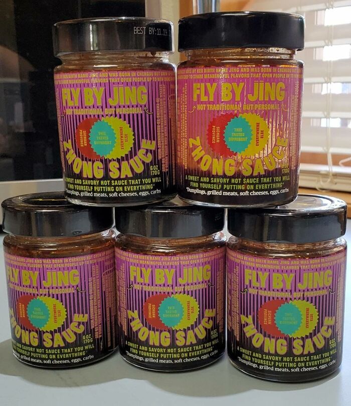 Five jars of Fly By Jing hot sauce stacked on kitchen counter