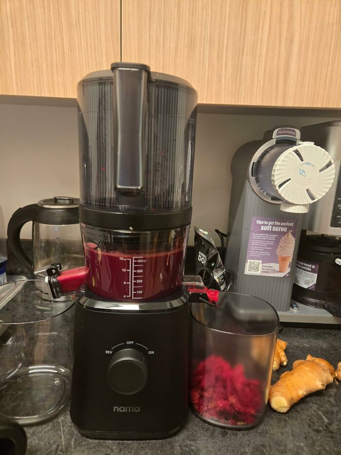 A Nama cold press juicer making red juice, a kitchen essential for healthy summer drinks during Prime Day.
