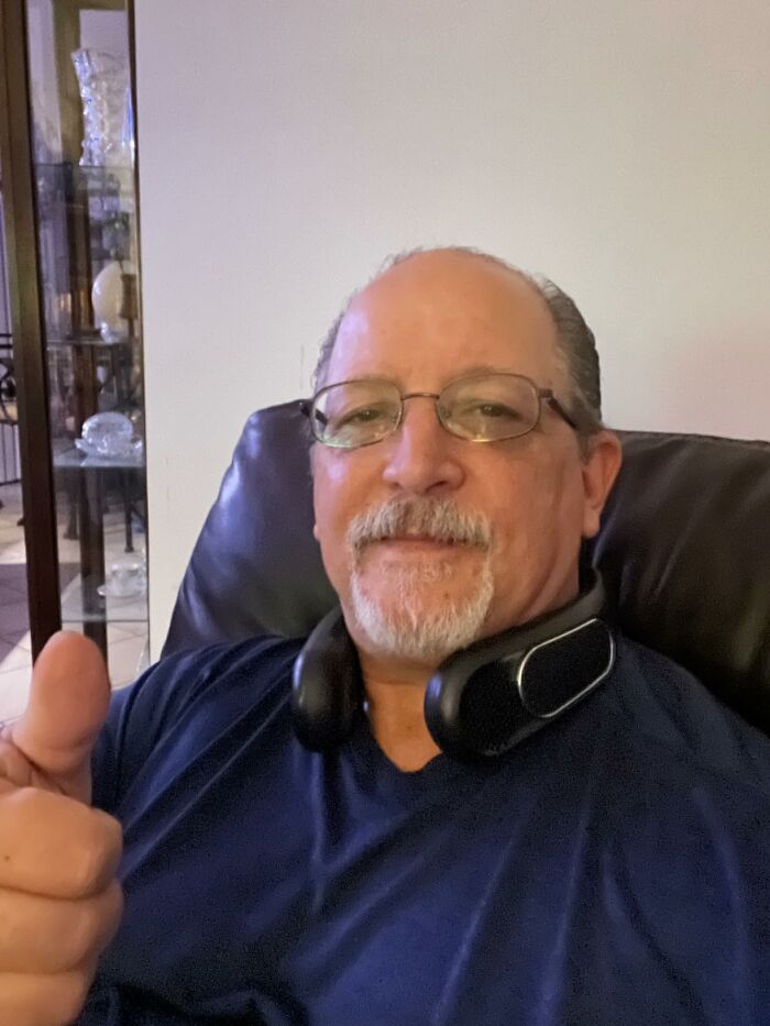 A man with glasses and a neck fan gives a thumbs up, enjoying Prime Day deals.