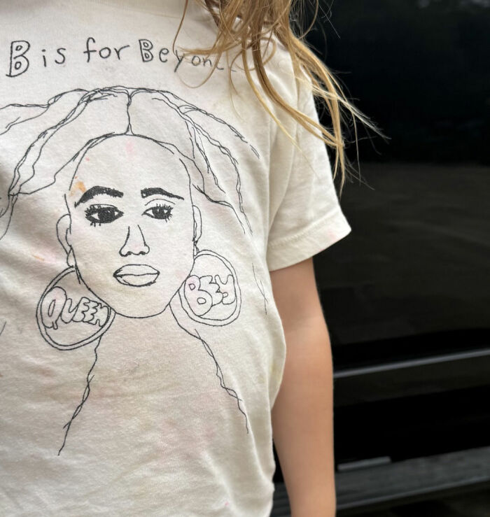 Child wearing t-shirt with Beyonce Queen Bey drawing and text