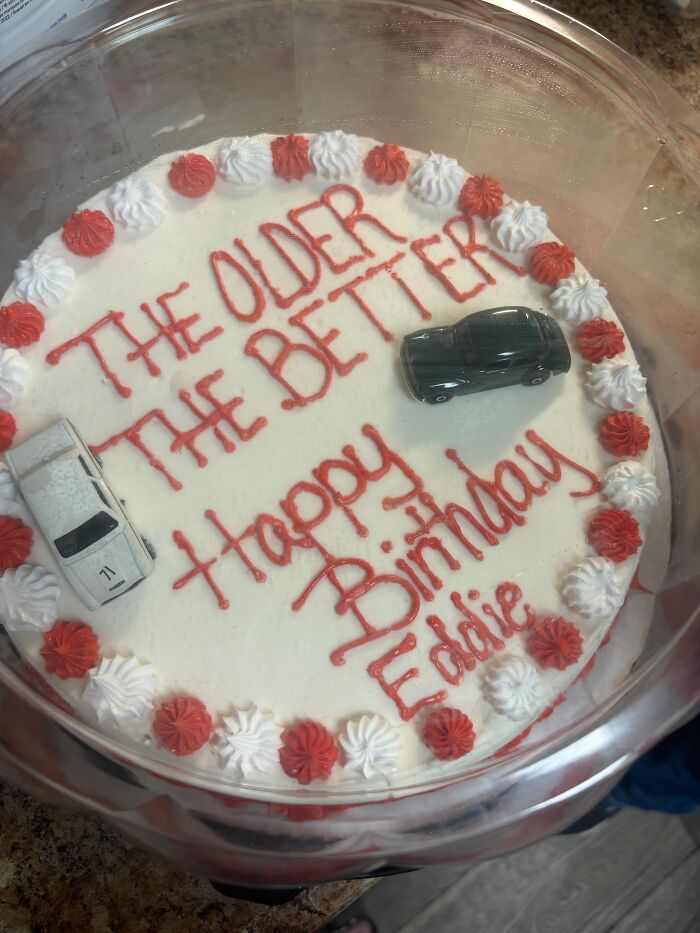 Funny cakes: A white round birthday cake with red icing that reads 'The older the better Happy Birthday Eddie' and two toy cars.