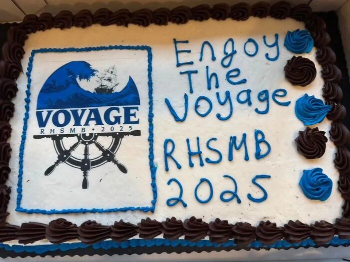 A large rectangular cake with 'Enjoy The Voyage RHSMB 2025' and a logo, not a funny cake.