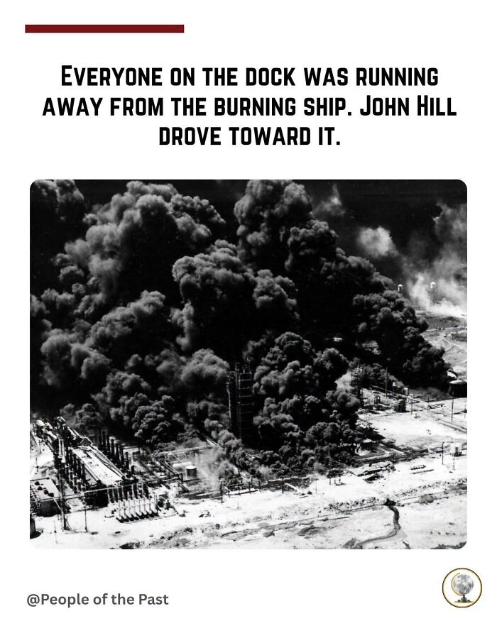 A black and white historical post of a burning ship at a dock with thick smoke billowing.