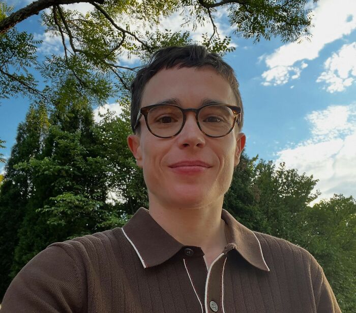 Smiling celebrity with glasses outdoors, with blue sky and trees in the background. Has this celebritys fame run out?