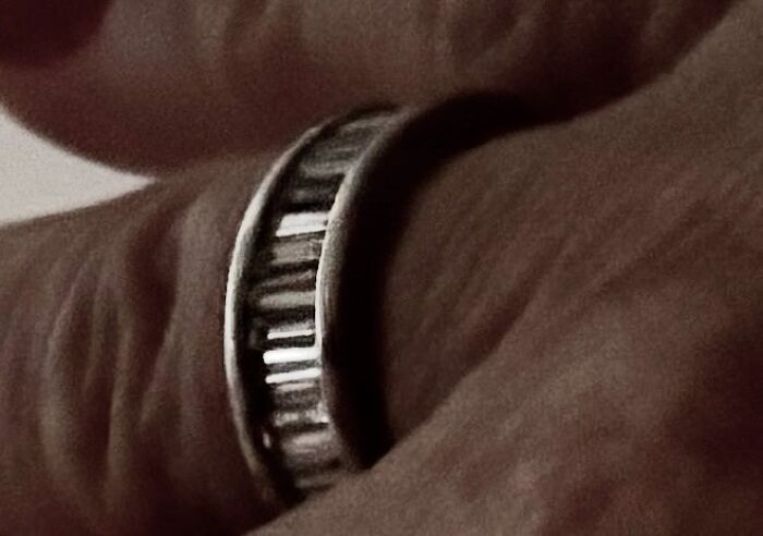 A close-up of a hand wearing a unique ring, experiencing something creepy.