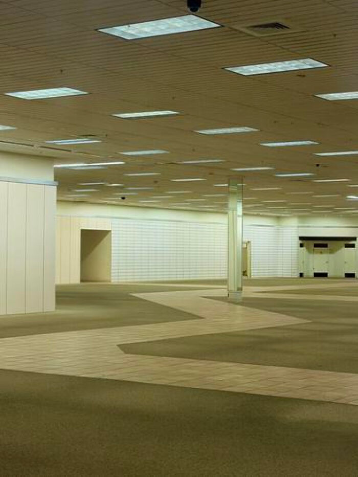 A vast, empty commercial building with a wavy carpet pattern, a classic example of a haunting liminal space.