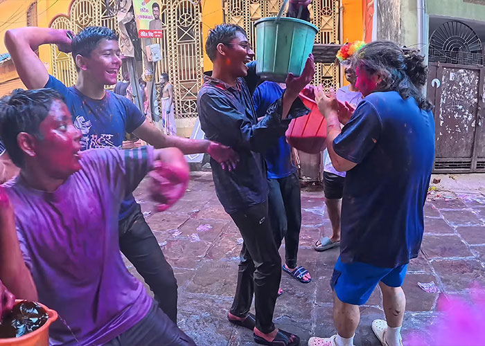 Group of men throwing water and powder at Korean man disguised as pregnant woman in India