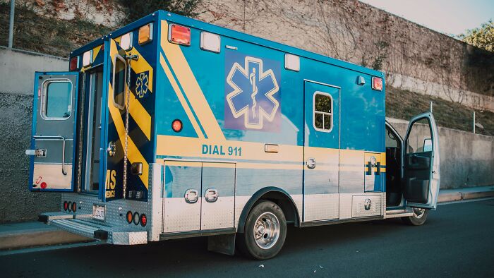 Ambulance vehicle parked on street with open doors in daylight