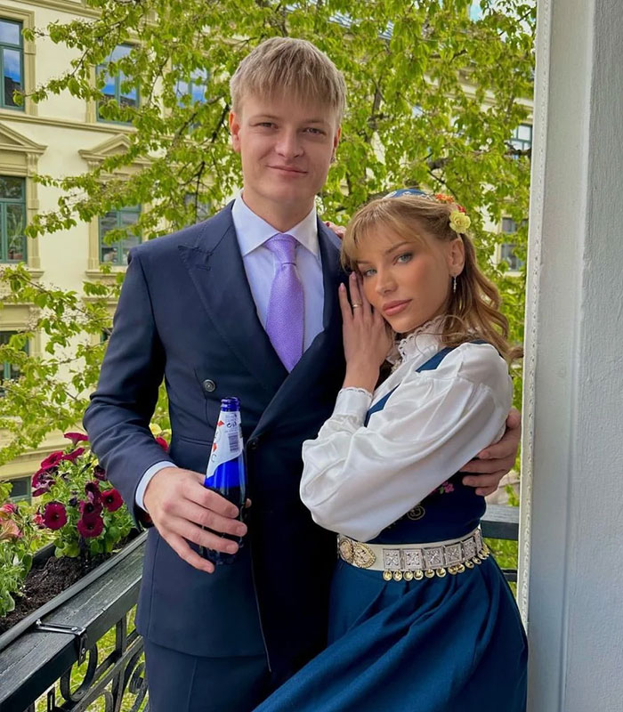Son of Norway's future queen with woman in traditional dress outdoors
