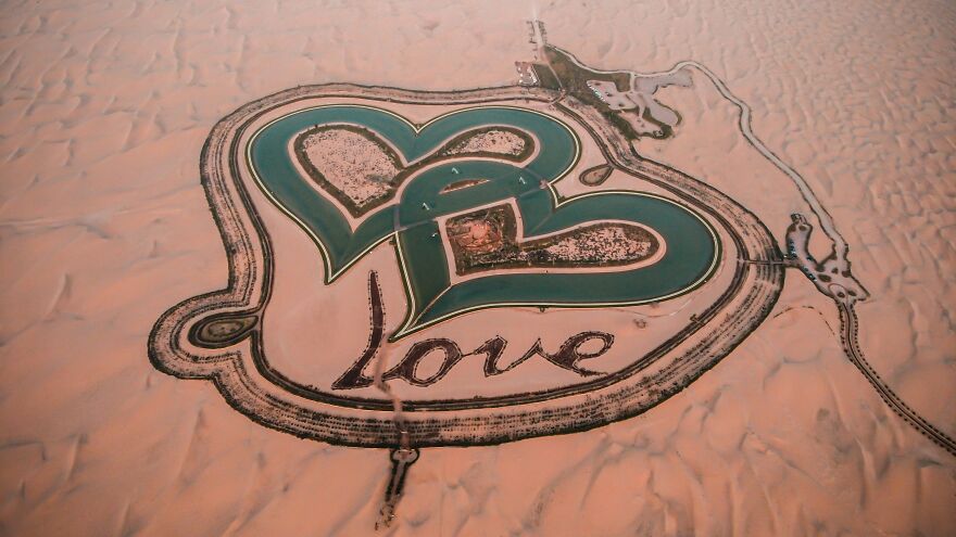 Heart-shaped water features with love sign in desert landscape