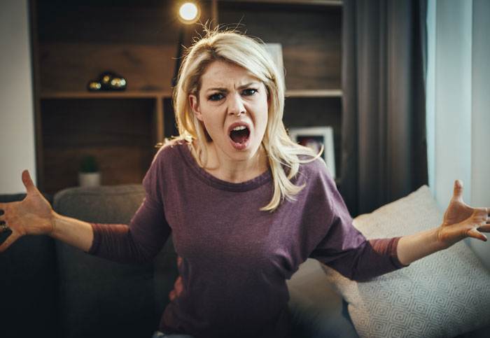 Angry woman appearing frustrated indoors raised by Karens