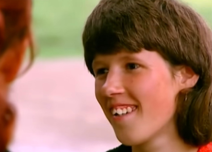 Close-up of the girl raised by dogs, smiling with her mouth slightly open, revealing her teeth. Close-up of the girl raised by dogs, smiling with her mouth slightly open, revealing her teeth.