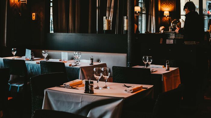 An empty restaurant with tables set for a date, focusing on acceptable actions during dating.