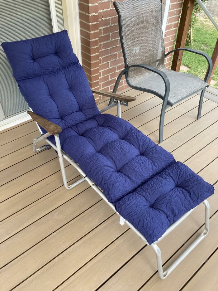 Prime Day outdoor and backyard essentials for summer, a dark blue cushioned lounge chair on a wooden deck.