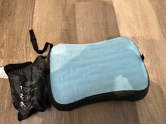 Blue portable neck and shoulder massager on wooden floor with carrying case