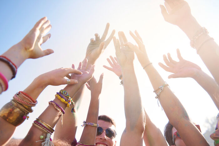 Many hands reaching up towards the sun, with a person smiling below. This image represents the scale of celebrity scandals and unhinged problems.