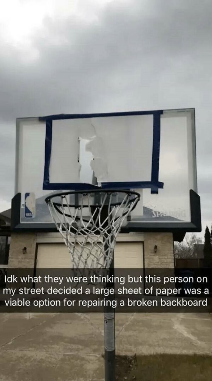 A basketball hoop with a broken backboard, patched with a large sheet of paper, a classic You Had One Job fail.