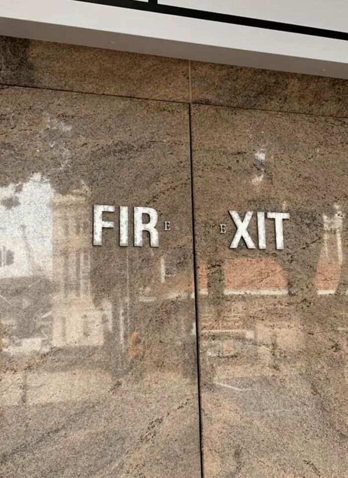 A stone wall with the words FIR and EXIT separated, a ridiculous you had one job fail showing common sense isn't common.