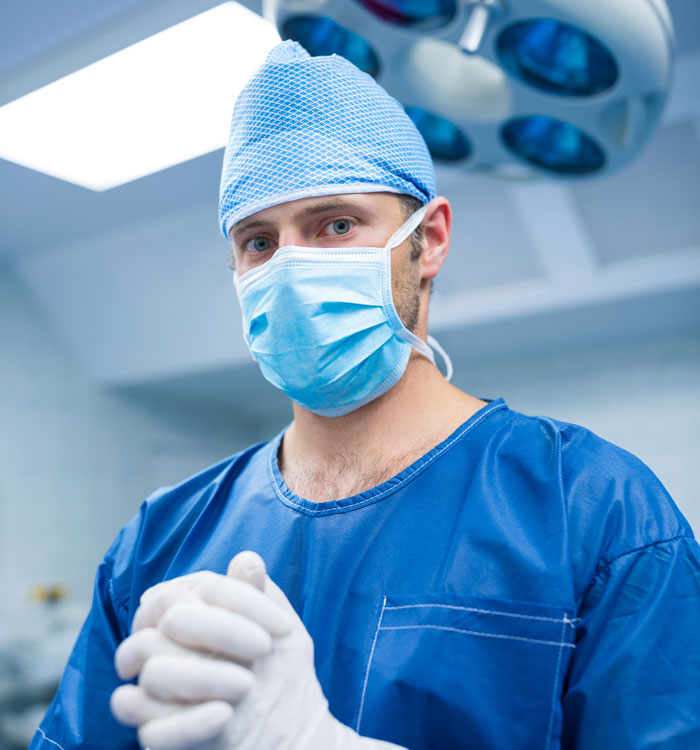 Healthcare professional wearing surgical mask and gloves in medical setting
