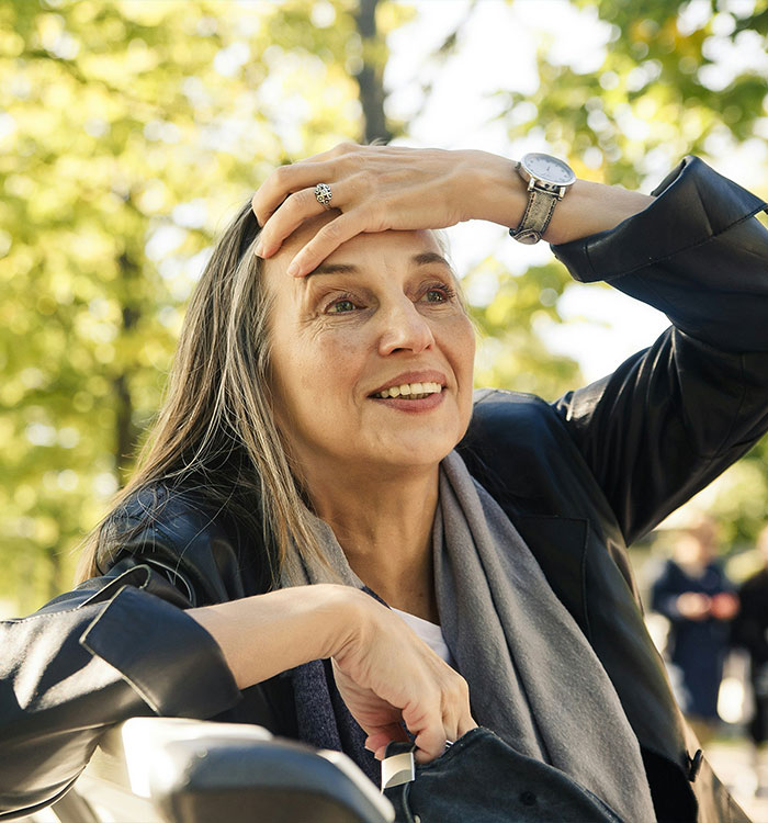 Happy postmenopausal woman outdoors after managing silent brain-sapper symptoms Happy postmenopausal woman outdoors after managing silent brain-sapper symptoms