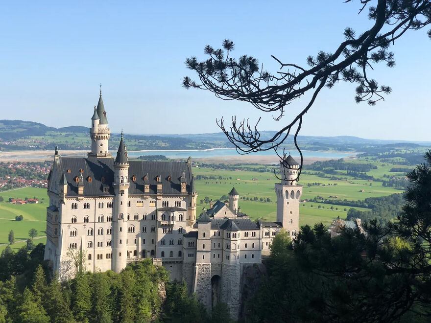 Fairy tale Neuschwanstein Castle atop a hill with distant landscape views