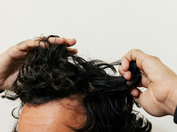 Man pulling and tangling hair depicting frustrating gross behavior