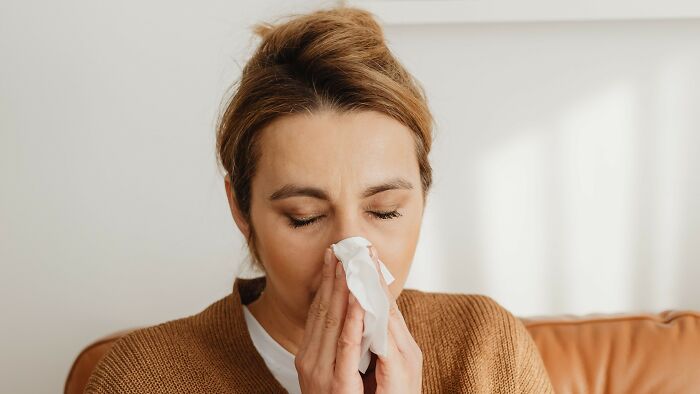 Woman blowing nose with tissue showing emotional challenge in mind-bending dilemmas