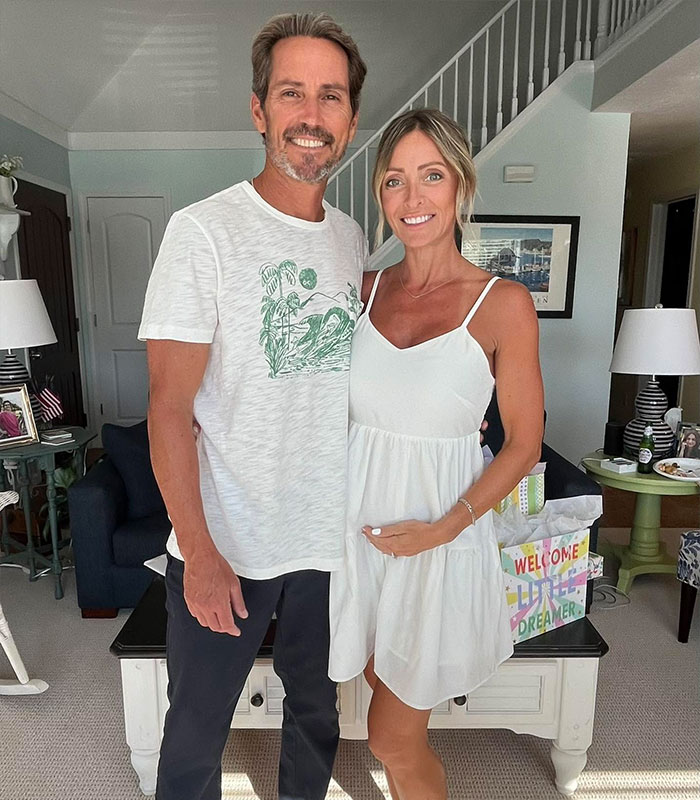 Smiling couple, pregnant woman cradling her belly, after IVF mix-up with wrong baby. Smiling couple, pregnant woman cradling her belly, after IVF mix-up with wrong baby.