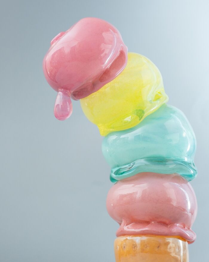 Stack of melting scoops of hyper-realistic glass food ice cream, an artist's creation that looks good enough to eat.
