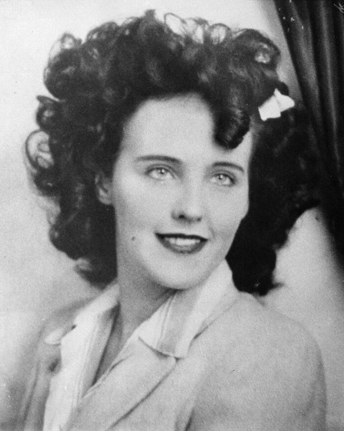 A black and white photo of a woman with curly hair and bright eyes, an image from unsolved mysteries.