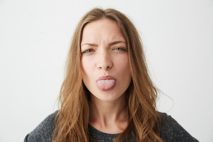 Woman sticking out tongue showing human body expression
