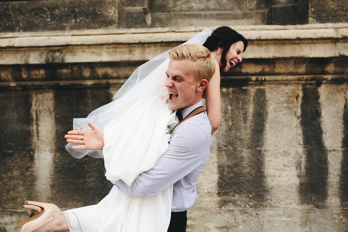 Happy bride and groom laughing during wedding celebration outdoors