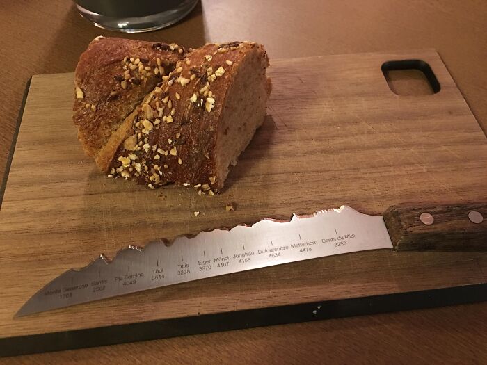 Bread knife with serrated edge shaped like mountain silhouettes and names engraved