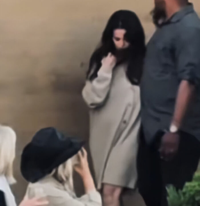 Selena Gomez in a beige dress with a slightly rounded stomach, sparking Selena Gomez pregnant rumors.