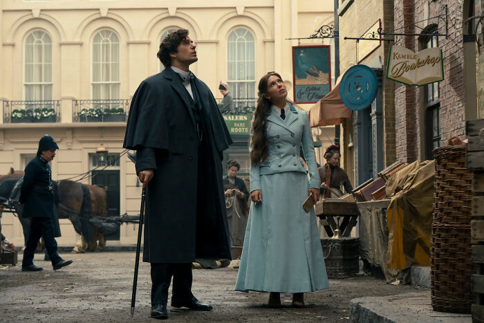 Millie Bobby Brown and Henry Cavill look up at the sky in a bustling street from the Netflix movie Enola Holmes 3. Millie Bobby Brown and Henry Cavill look up at the sky in a bustling street from the Netflix movie Enola Holmes 3.