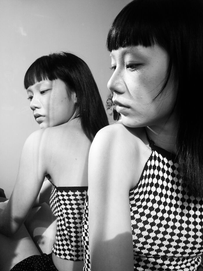 Black and white portrait of woman reflecting raw beauty of human spirit in mirror