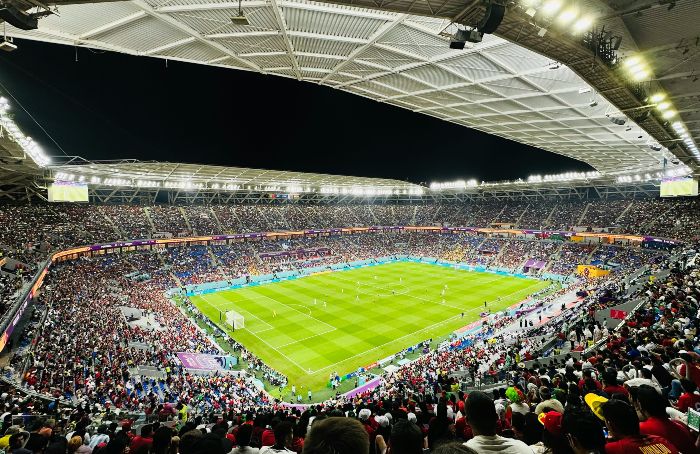 An aerial view of the World Cup stadium with a full crowd and a game on the field.