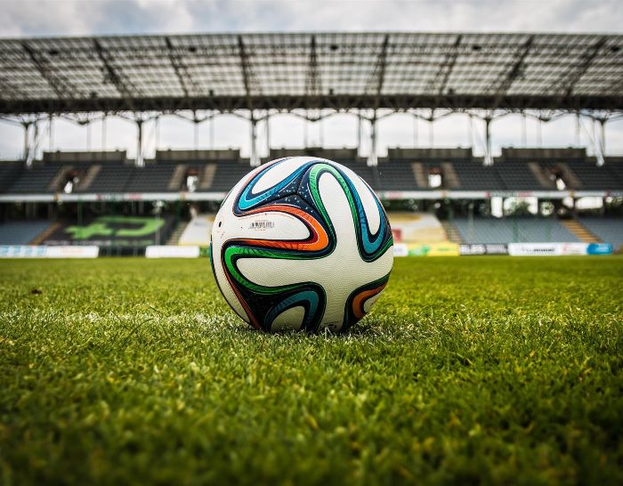 A soccer ball on the green grass of a World Cup stadium before a game.