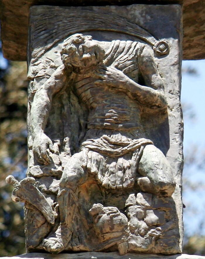 Ancient stone carving of a muscular figure, symbolizing historical acts of revenge