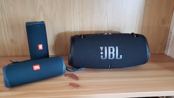 Three JBL Bluetooth speakers on a wooden shelf, offering Prime Day Electronics Deals.