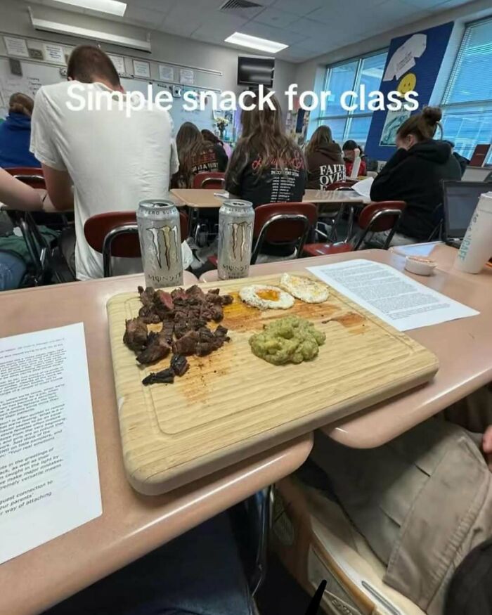 Classroom snack with steak, eggs, guacamole, and energy drinks on a wooden board